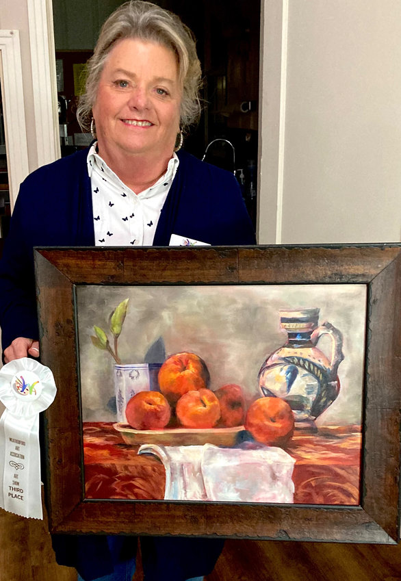 Cindi Neverdousky shows her third-place entry, an oil painting, “Peaches.”