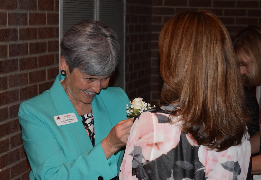 Assistant Superintendent Lynn McKinney pins corsages on nominees during the 2016 Marva Colluns Awards.