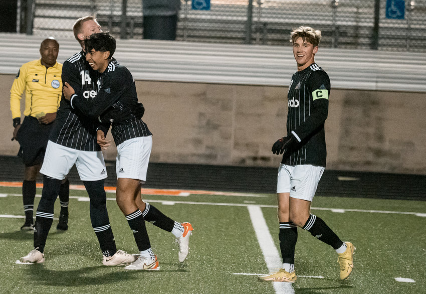 Adrian Solis celebrates with teammate Cole Crawford after scoring what ended up being the game-winning goal late in the second half of the Bearcats match with Saginaw on Friday, Feb. 24.