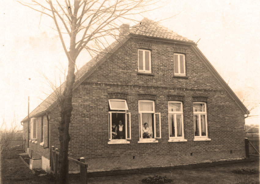 'Katie' Gisela's childhood home just outside of Oldenburg, Germany.  She lived on the left side. Animals were kept inside the back portion (an area called the 'diele'), where you'd also find indoor outhouses. Katie's paternal grandmother and two of her aunts can be seen in the windows. The home is still standing and occupied today.  
