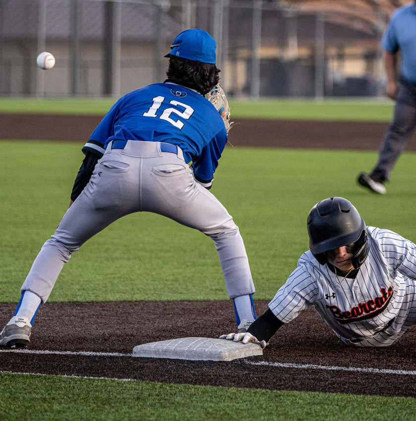 Boyd Thompson slides safely back into first base during an attempted pickoff in the first inning of the District opener on Tuesday, March 21.
