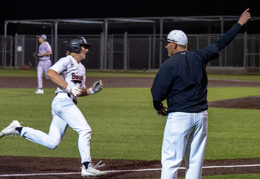 Bearcats skipper Chad Barry waves Bosten Dwinell home as he rounds third base after Andrew Cambre's base-clearing double in the bottom of the fifth inning on Friday, March 31.