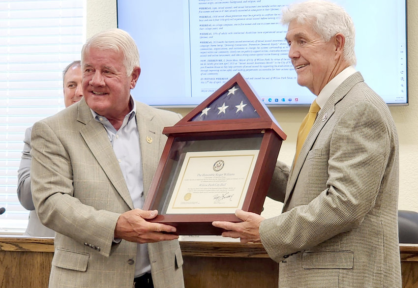 U.S. Congressman Roger Williams (right) presents an American flag to Willow Park Mayor Doyle Moss to celebrate the move into the new city hall. The presentation was made at the April 11 city council meeting.