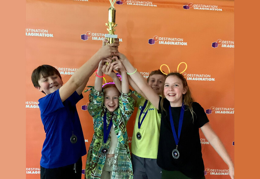 Mighty Bananas team members (from left) Oliver Wight, Sophia Stamper, Garrett Condon and Campbell Hutcheson hold up the regional championship trophy for Destination Imagination competition.
