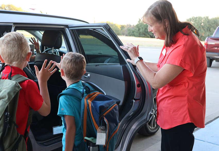 School Board member Jennifer Taylor helps with the drop-off of sudents at Stuard Elementary School on opening day.