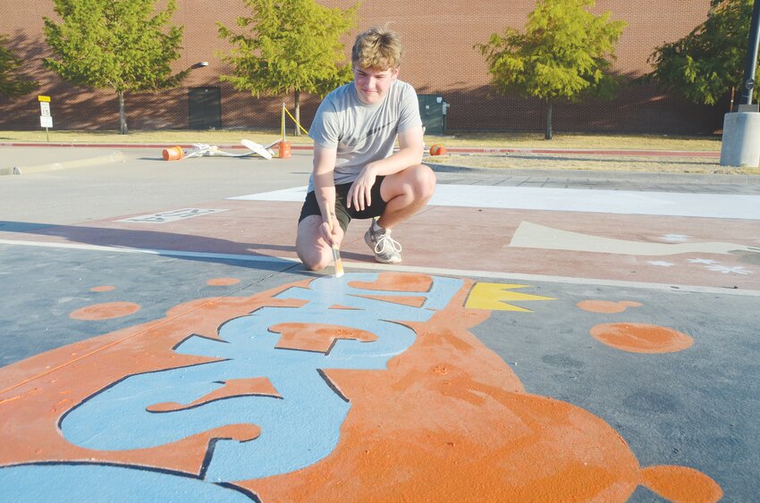 Jackson Babb spruces up his personal parking space at Aledo High School to prepare for his senior year.