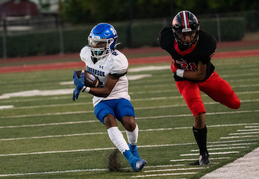 Wide receiver Micah Evans skirts the sidelines as he evades a Burleson defender.