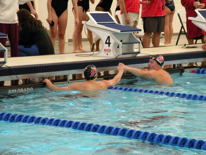Aledo swimmers Porter Lane (left) and Derek Smith exchange a fist bump after competing in the 100-yard breaststroke in the Northwest ISD Invitational on Saturday, Oct. 14.