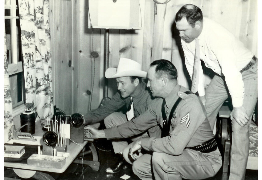 Roy Rogers, an unidentified officer, and Bob Rothel ook at targets.