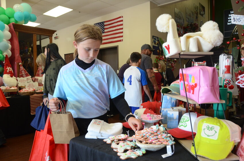 Stuard Elementary fourth-grader Candence Weaver considers Christmas gifts at the Trinity Christian Academy Gift Fair. The event drew hundreds of shoppers to 55 vendor booths.