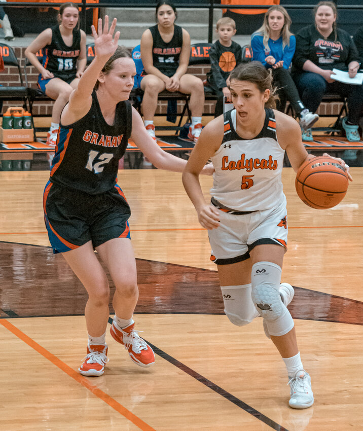 Caroline Browning dribbles around a Graham defender during varsity hoops action last season. Browning led the Ladycat scoring in the season opener on Saturday, Nov. 4 with 15 points.