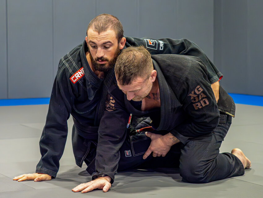 Coach Devin Miller and Combat Manager, Len Bentley display techniques for the adult gi jiu jitsu class at Fortified Fitness.