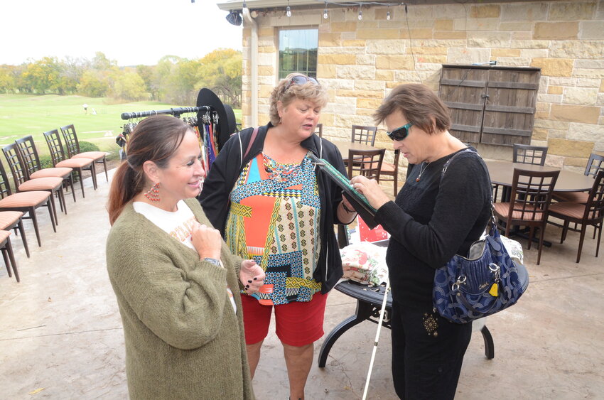 Amber Fogelman of The Wondering Turquoise shows jewelry to Angela Keith and Toni Marie Clavin.