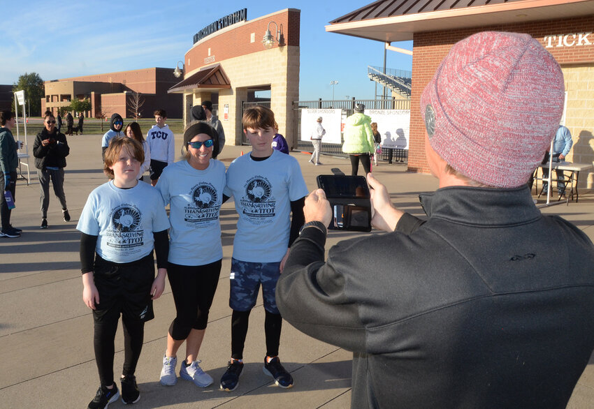 Aaron Fields helps with a pre-race group photo for the Vida family, Adrian, Luke, and Amy.