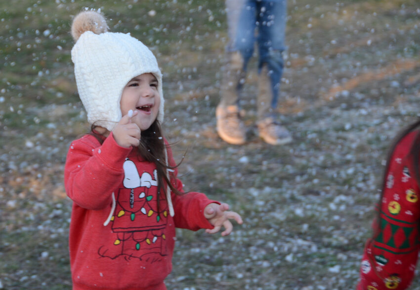 Three-year-old Julieta Busby delights in a snowflake she caught on the end of her finger at Christmas Time in Aledo on Dec. 2.