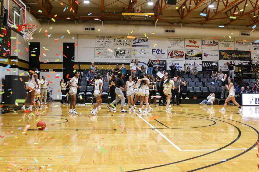 Weatherford College women’s basketball coachBob McKinley celebrates his 1,000 wins with members of the Lady Coyote players.  