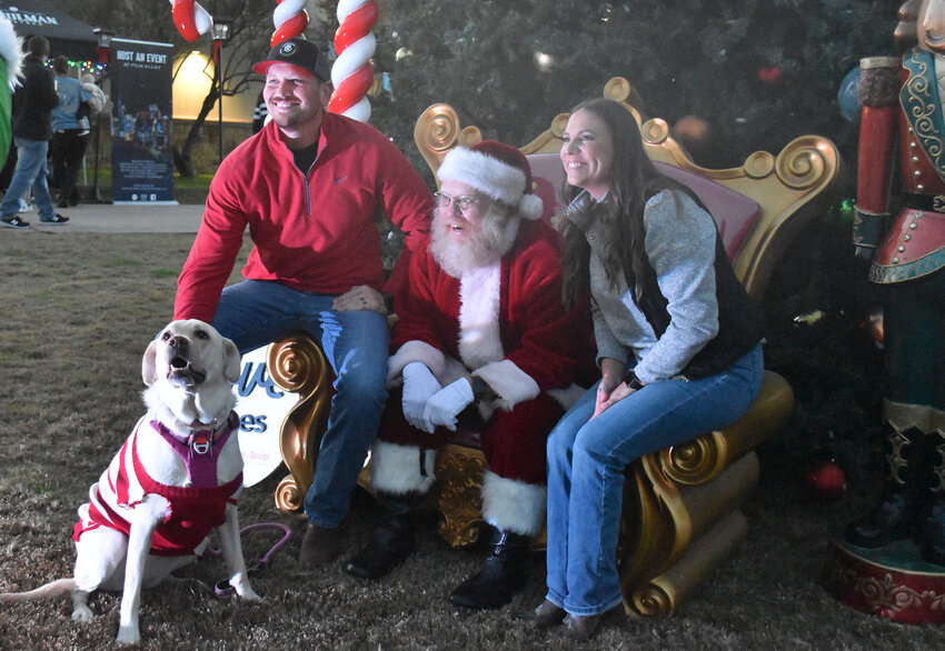Eric and Shelby Moore and their dog Luna pose for a photo with Santa.