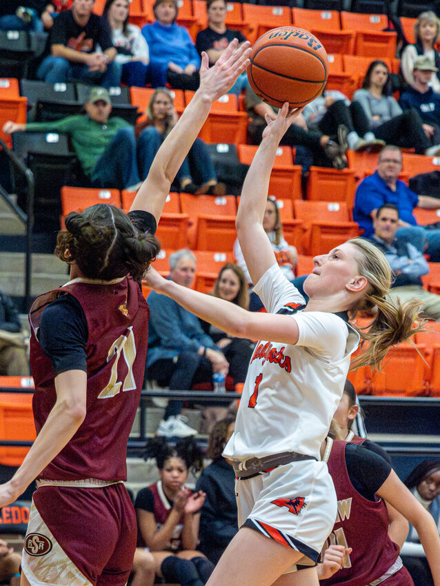 Aledo's Natalie Anderson lobs a shot over a Saginaw player for two of her 16 points in the game. The Ladycats won 85-20 on Tuesday, Dec. 19, to remain undefeated in District 5-5A play.