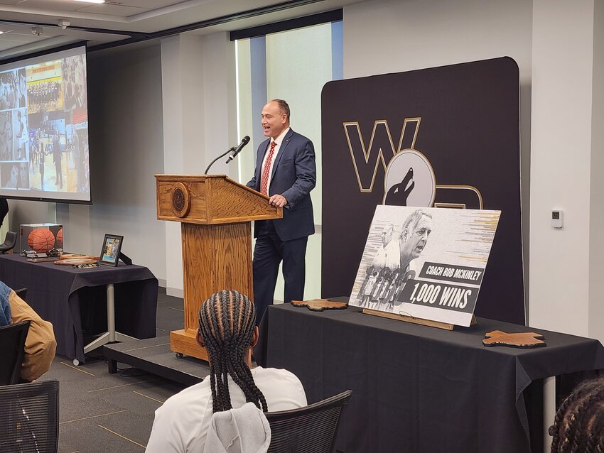 Weatherford College President Tod Allen Farmer congratulates Lady Coyotes coach Bob McKinley on his 1,000th career win at a reception honoring the coach.