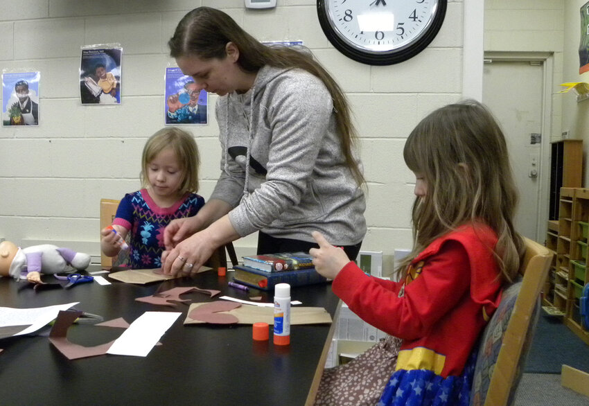 Virginia Rudibaugh helps daughters Ava and Bri with a craft after children’s story time at East Parker County Library.