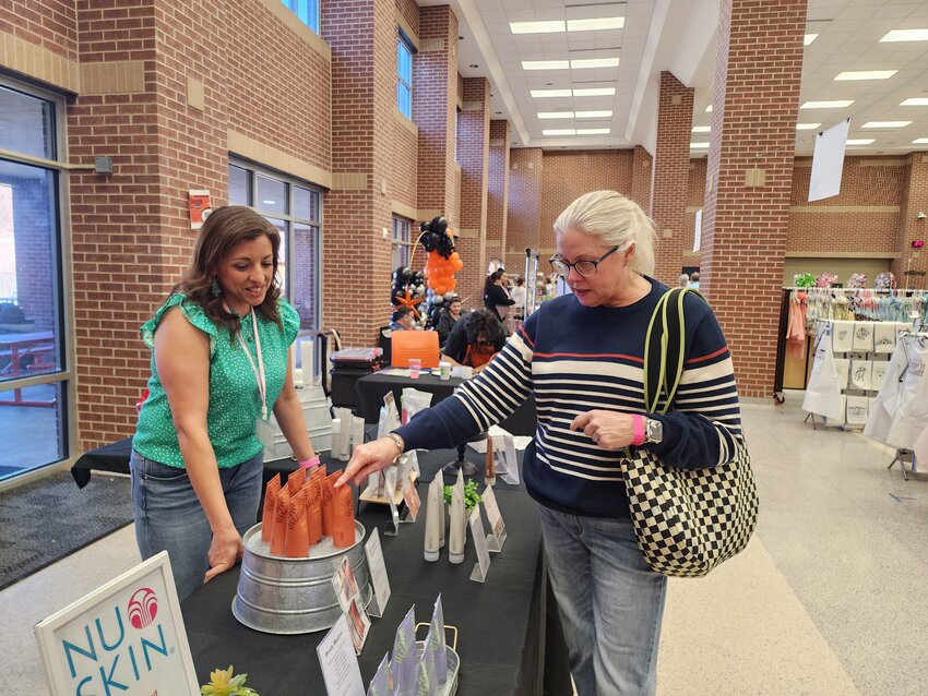 Aledo resident Aledo Dana Wilson stops by one of the vendor tables that featured skin care, oral care and wellness products being sold by Ana Dowling, left, at the Aledo Spring Fling March 2.