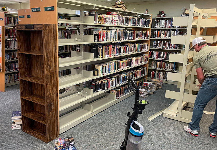 A worker dis-assembled sections of shelving in 2016 when the library received new shelves that expanded some capacity after ordering them almost a year before.