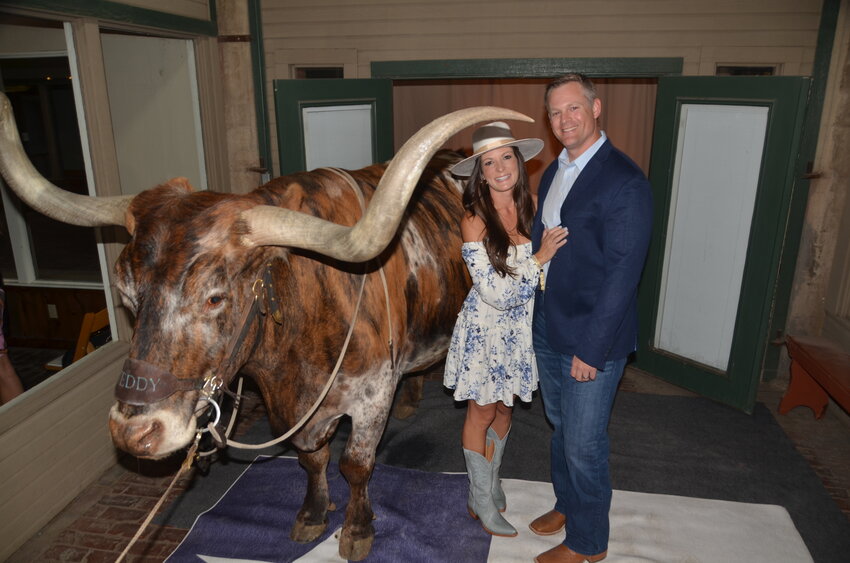Preston and Erin Stone pose with Teddy the Texas Longhorn, a massive steer herded into the entry to greet guests. The couple live in Annetta North and own Grounds for Hounds veterinarian clinic in Willow Park.