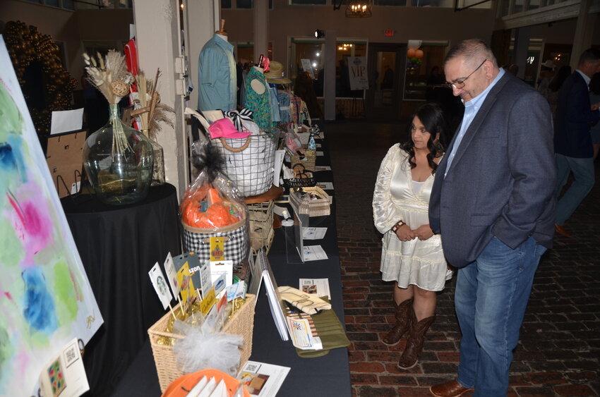 Ray and Diana Cortinas look at silent auction items.