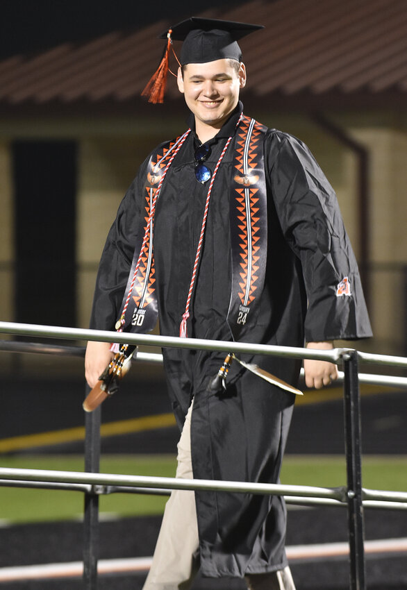Hunter Gregory prepares to cross the stage in his Native American regalia at the Aledo High School graduation ceremony on May 24.
