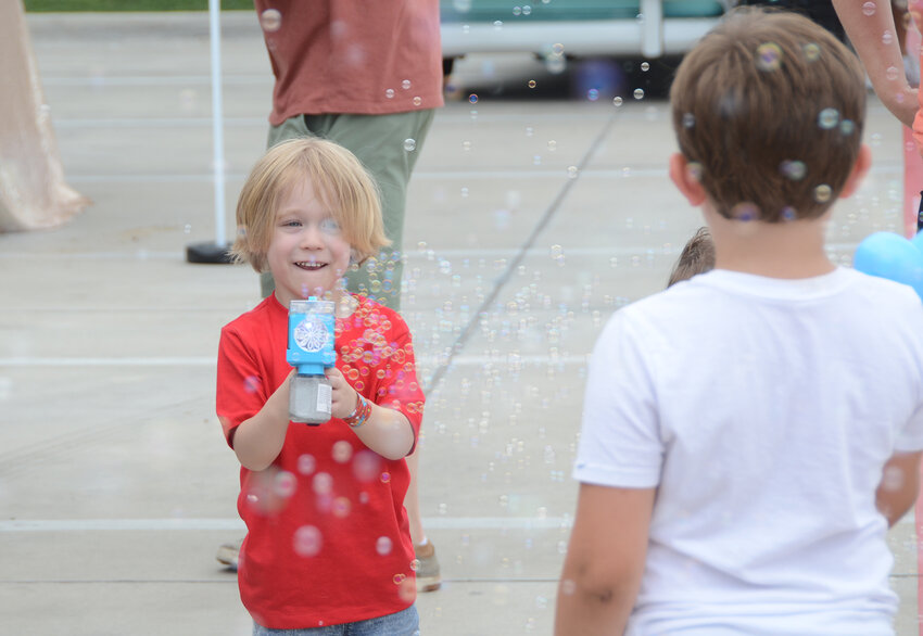 Tyler Hopkins uses a bubble gun to keep his friends at bay at the Willow Park Palooza on June 1.