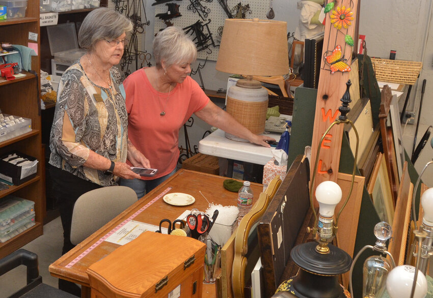 Volunteers Sharon Tidwell and Sharon Haught research and prepare merchandise before going on the display floor at The Hope Chest, the Center of Hope’s upscale resale shop.