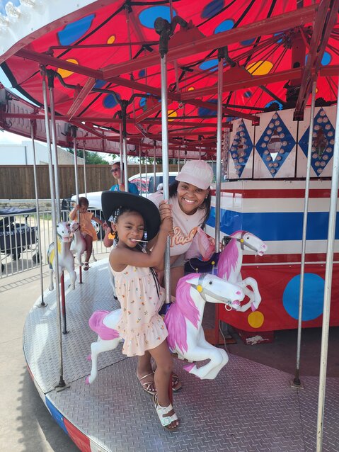 Christian Smith and her daughter, first-time visitors from Fort Worth, prepare for a good time on the merry-co-round.