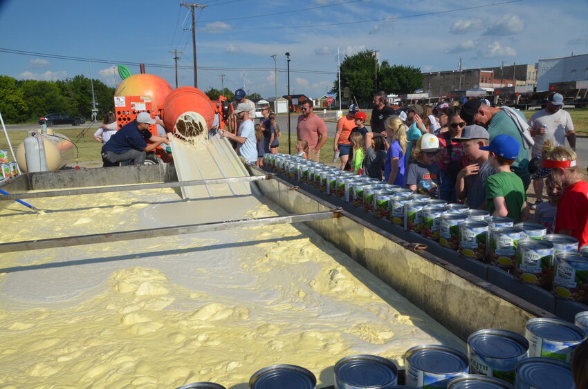 Watching the mixing of the world record peach cobbler was a festive event with volunteers helping fill five gallon buckets of batter and pouring the batter and canned peaches.