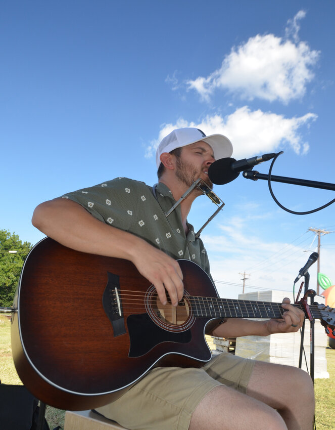Musician Toby Hutchinson provided entertainment for the spectators watching the giant peach cobbler mixing.