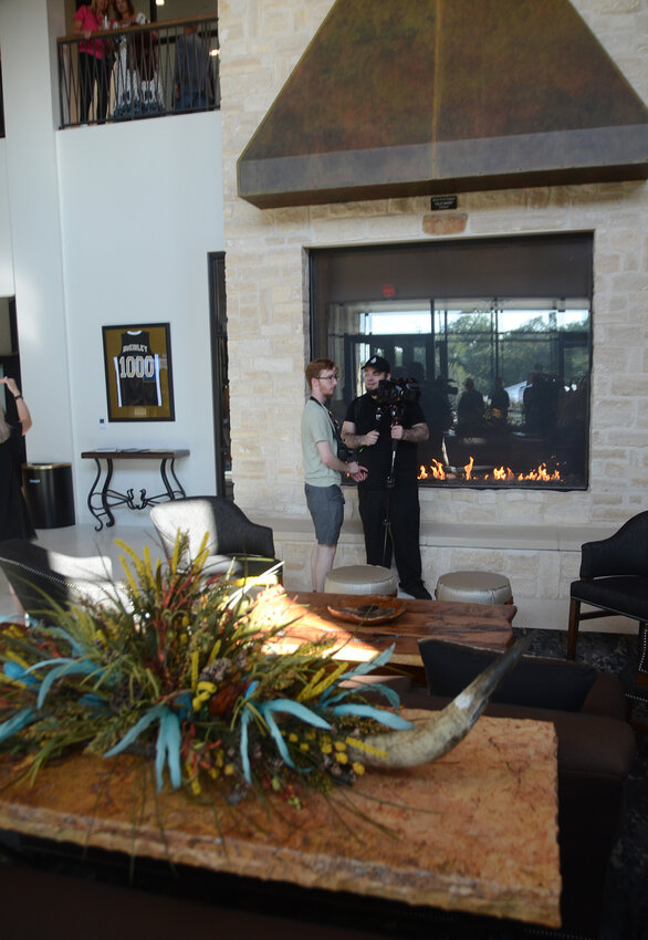 The lobby of Durant Hall features a conference area, comfortable seating, antler chandeliers, and a massive fireplace.