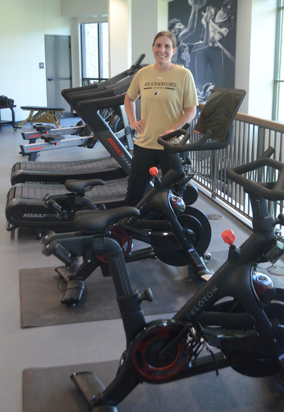 Volleyball coach Kailee May greets visitors in the cardio workout room on the second floor.