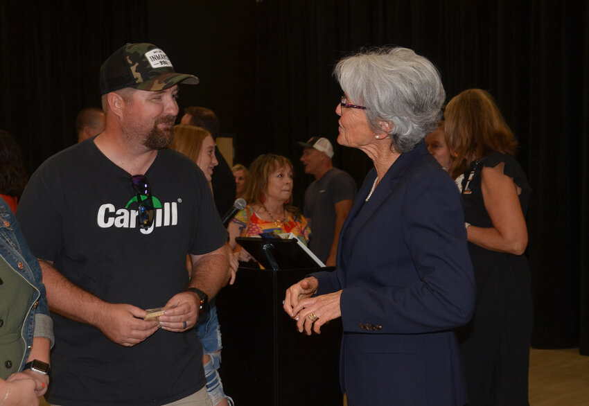 Charlie Needham speaks with his former high school principal, Lynn McKinney. His wife, Suzanne, is an educator at the school.