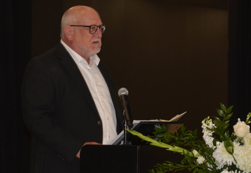 Randal McKinney, also a retired AISD educator, introduces the person of honor, his wife.