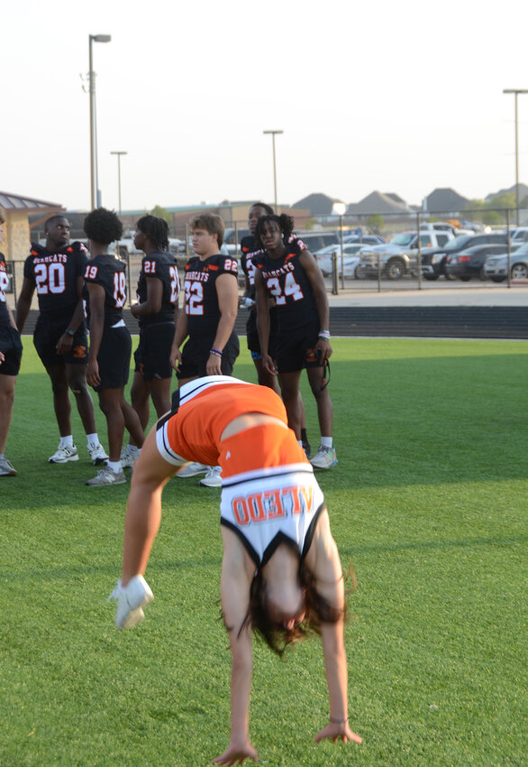 Cheerleader Charlotte Zirbser flips for the Bearcats.