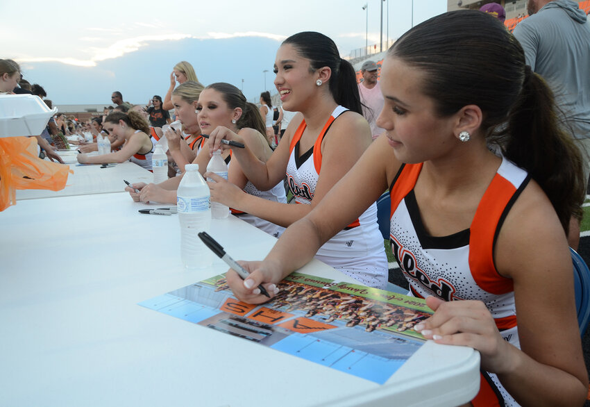 Ellie Dann signs the Aledo Cheerleader poster for a fan.