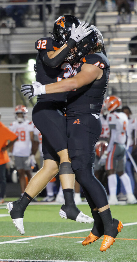 Linebacker Chase Wilburn (32) and defensive end Cooper Cyphers (42) celebrate a big stop.