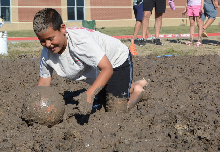 Liam Mendoza nudges a ball through mud using only his head, a slimy requirement for the mud ball race.