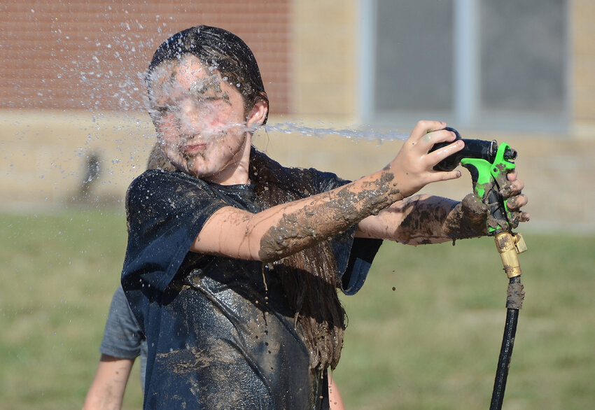 Sophia Broussard hoses off after she and her friends spent an hour smearing mud on each other.