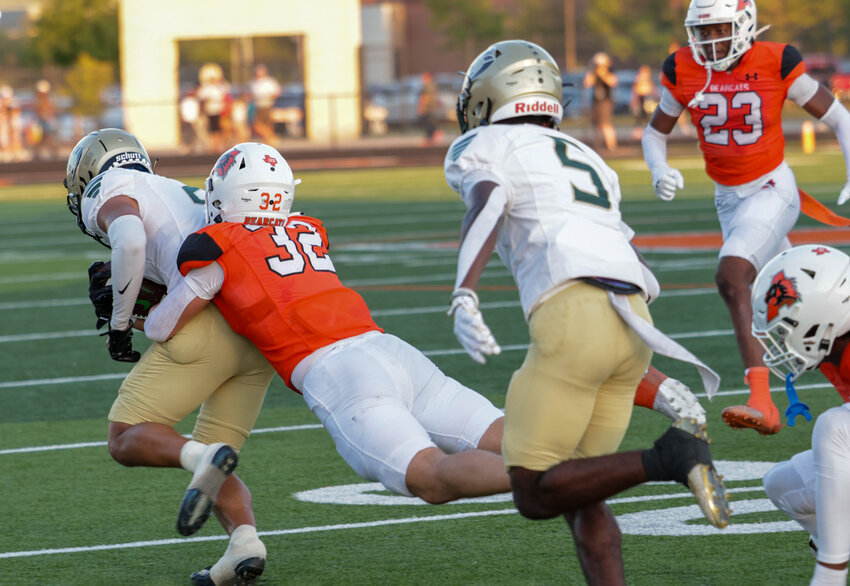 Chase_Wilburn (32) makes a tackle. Also shown is Kamron Hall (32).