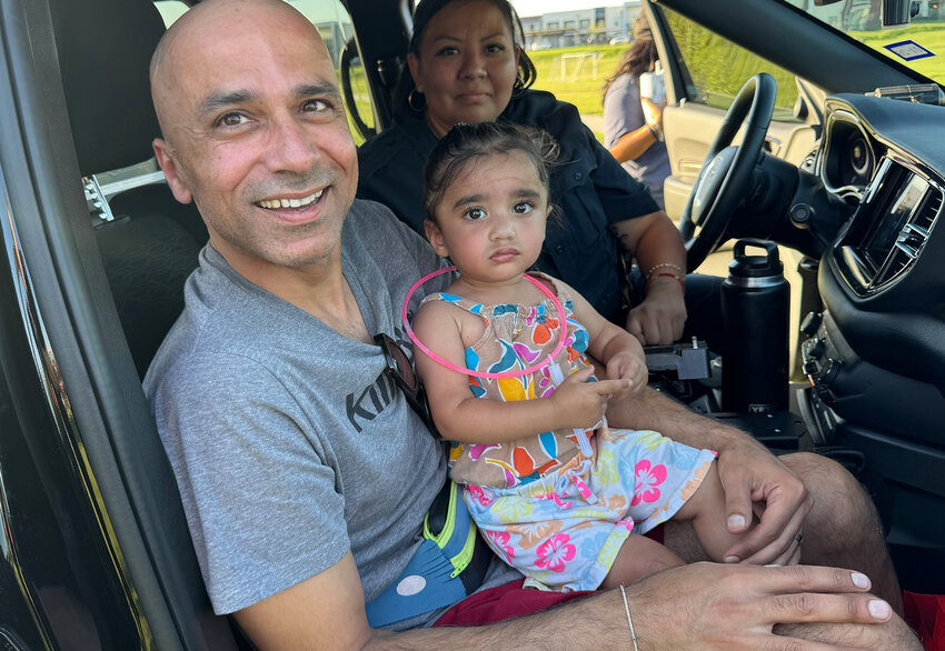 Vic Kapur and daughter Zoe check out the inside of a police car.