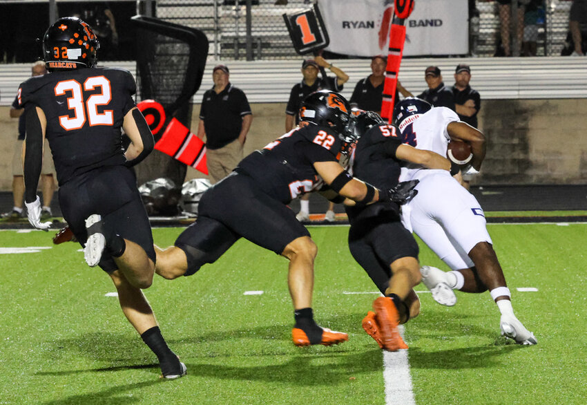 Chase Wilburn (32), Ben McElree (22), and Ryland Haley (57) stop a Denton Ryan ball carrier.