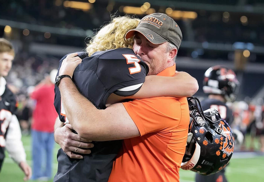 Derek celebrates with son Reid following the 2016 Aledo football state championship.