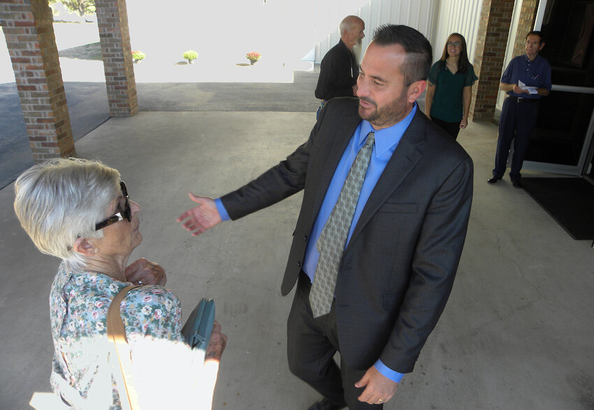 Pastor Brandon Carter welcomes Judy Bird of Aledo to the grand opening of the New Faith Baptist Church new sanctuary.