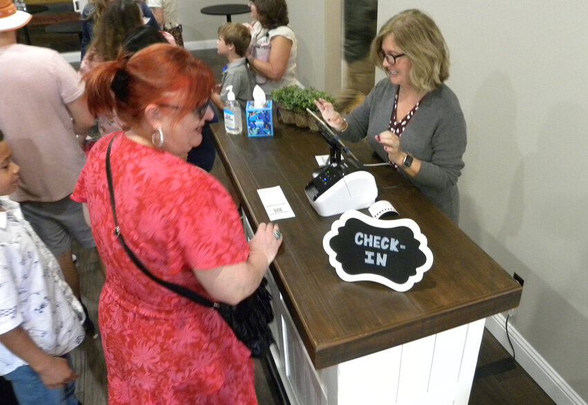 Kelly Moore checks in kids for childrens’ church, which now occupies the old sanctuary.