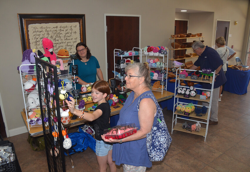 Kinley Morrow shops one of the booths at Aledo Methodist Church Lord's Acre with grandmother, Joyce Echstein.